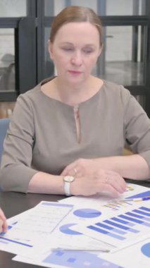 Eski İş Kadını Kadın Meslektaşı ile Belgeler Üzerinde Çalışıyor, dikey video