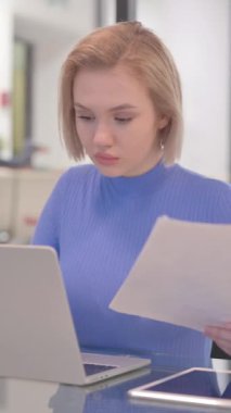 Genç Kadın Belgeler ve Laptop Üzerinde Çalışıyor, dikey video