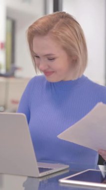 Genç Kadın Laptop ve Belgeleri Kullanırken Kutluyor, dikey video