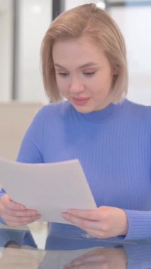 Belgeleri okurken kutlama yapan genç kadın, dikey video