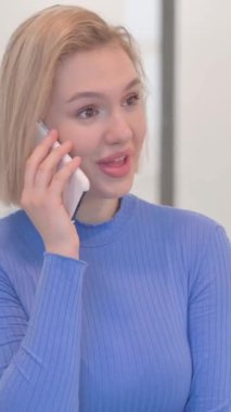 Telefonda konuşan genç kadının portresi, dikey video.