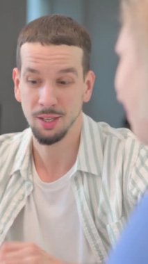 Yaratıcı Genç Adam Takım Arkadaşlarıyla Konuşuyor 'un dikey videosunu kapat