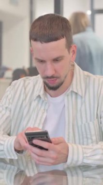 Ofiste İnternet 'e göz atan yaratıcı genç adam, dikey video