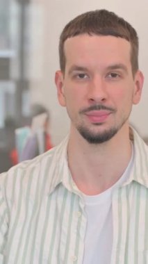 Merhaba demek için el sallayan yaratıcı genç adamın portresi, dikey video