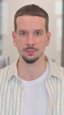 Kamerayı gösteren yaratıcı genç adamın portresi, dikey video