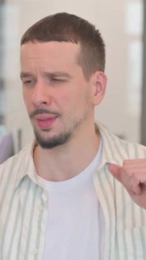 Telefon kullanan yaratıcı genç adamın portresi, dikey video