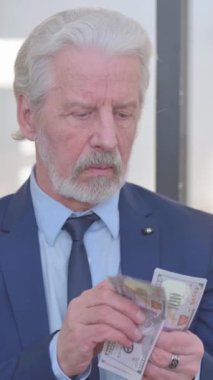 Para sayan yaşlı iş adamının portresi, dikey video