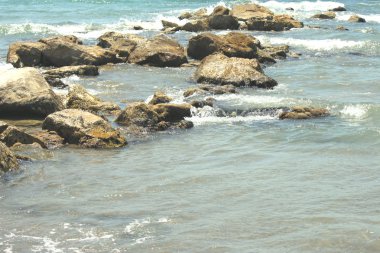 Plaja yakın bir şeffaf deniz suyu içinde büyük taşlar