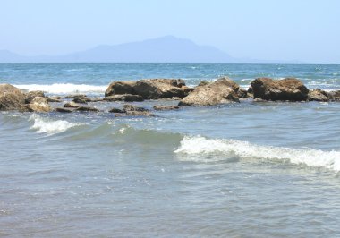 Plaja yakın bir şeffaf deniz suyu içinde büyük taşlar