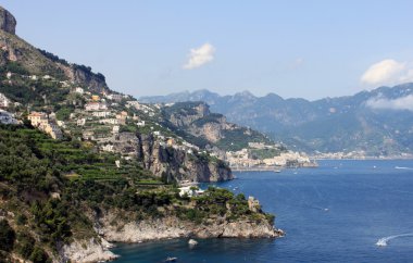 Deniz, kayalar ve geleneksel İtalyan mimarisi gün batımında güzel manzara. Amalfi Coast, İtalya.