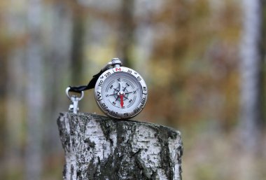 Pusula ile turizmin sembolü olarak doğal arka planda yuvarlak pusula, pusula ile seyahat ve pusula ile açık hava aktiviteleri