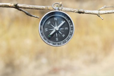 Pusula ile turizmin sembolü olarak doğal arka planda klasik navigasyon pusulası, pusula ile seyahat ve pusula ile açık hava aktiviteleri