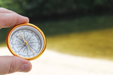 Pusula ile turizmin, pusula ile seyahat etmenin ve pusula ile açık hava aktivitelerinin sembolü olarak, doğal arka planda eski klasik navigasyon pusulası bulunmakta