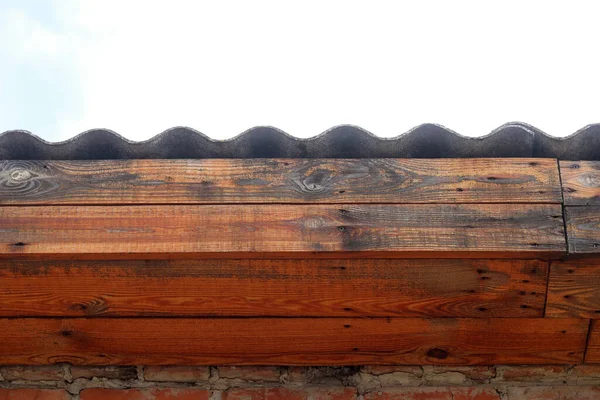 蓝天背景下木制横梁上灰色波纹板做的房顶 有文字记载 — 图库照片