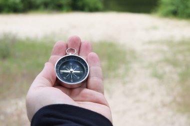 Pusula ile turizmin, pusula ile seyahat etmenin ve pusula ile açık hava aktivitelerinin sembolü olarak, doğal arka planda eski klasik navigasyon pusulası bulunmakta