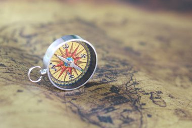 Turizmin sembolü olarak eski dünyanın klasik klasik klasik klasik arka planında pusula, pusula ile seyahat ve pusula ile açık hava aktiviteleri