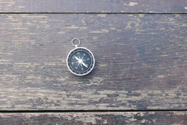 Pusula ile turizmin sembolü olarak doğal ahşap arka planda yuvarlak pusula, pusula ile seyahat ve pusula ile açık hava aktiviteleri