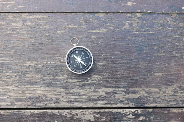 Pusula ile turizmin sembolü olarak doğal ahşap arka planda yuvarlak pusula, pusula ile seyahat ve pusula ile açık hava aktiviteleri
