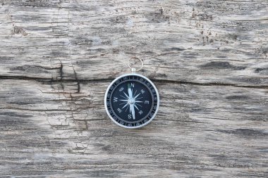 Pusula ile turizmin sembolü olarak doğal ahşap arka planda yuvarlak pusula, pusula ile seyahat ve pusula ile açık hava aktiviteleri