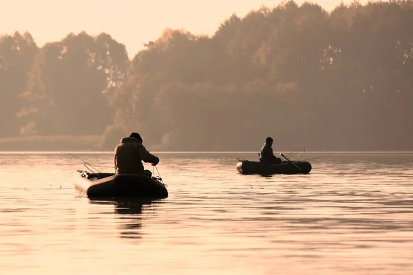 Pêcheurs dans un bateau attrapant des poissons tôt le matin — Photo