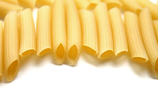 Some raw penne macaroni on white background — Stock Photo, Image