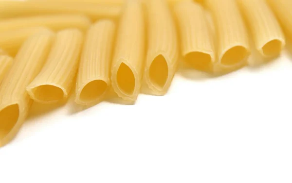 Some raw penne macaroni on white background — Stock Photo, Image