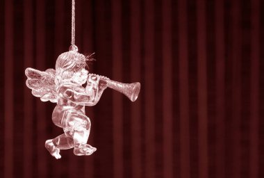 Güzel çizgili kırmızı arka planda cam melek Noel ve yeni yıl kutlamalarının sembolü olarak