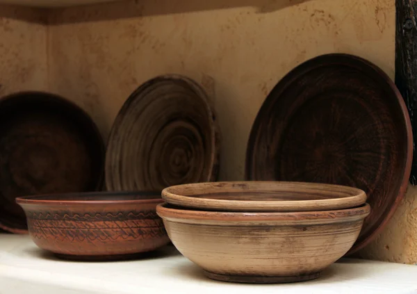 Clay plates on a shelf close-up — Stock Photo, Image