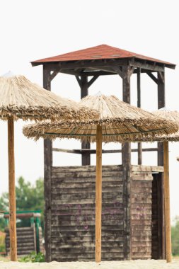 Hasır şemsiyeler ve bir plajda cankurtaran watchtower. Fotoğraf ile 