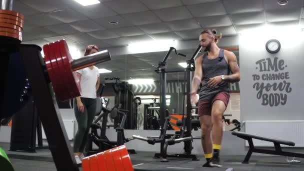 Gimnasio Lección con un joven entrenador divertido hombre Una aspirante a mujer joven se abalanza — Vídeos de Stock