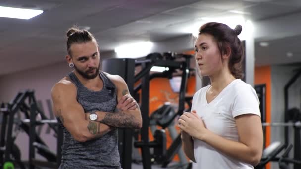 Gym Lesson egy fiatal vicces edző férfi Egy törekvő fiatal nő tüdő — Stock videók