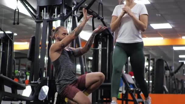 Gimnasio Lección con un joven entrenador divertido hombre Una aspirante a mujer joven se abalanza — Vídeo de stock