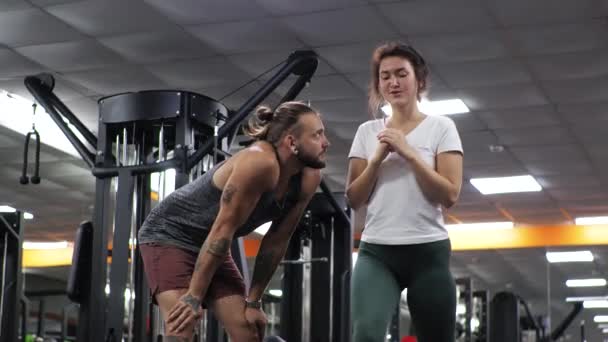 Gimnasio Lección con un joven entrenador divertido hombre Una aspirante a mujer joven se abalanza — Vídeos de Stock