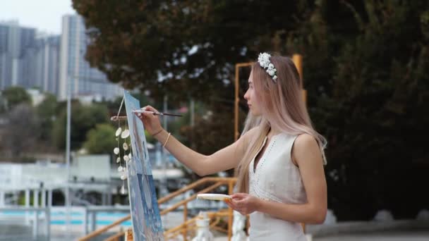 Mladá blondýna žena maluje obrázek na městské pláži na čerstvém vzduchu — Stock video