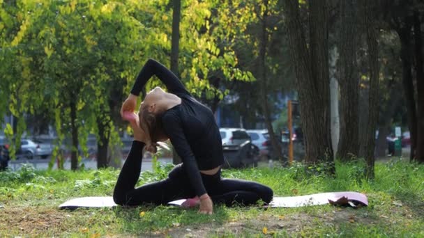 Genç bir kadın şehir parkında yoga yapıyor çimlerin üzerinde — Stok video