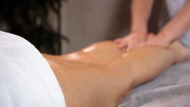 Vrouw masseur doen benen massage ontspannen massage op een donker warme achtergrond — Stockvideo