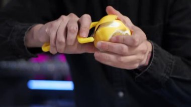Genç acemi barmen stajyer bir kokteyl hazırlarken alkolsüz limonata için limon keser.