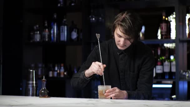 Νέοι αρχάριοι εκπαιδευόμενοι μπάρμαν ετοιμάζουν ένα κοκτέιλ Careless τύπος Αναμιγνύει ποτό και πάγο σε ένα σέικερ — Αρχείο Βίντεο