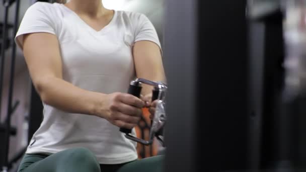 Gym-Unterricht mit einem jungen, lustigen Trainer Eine Anfängerin schüttelt am Simulator Rücken und Arme — Stockvideo