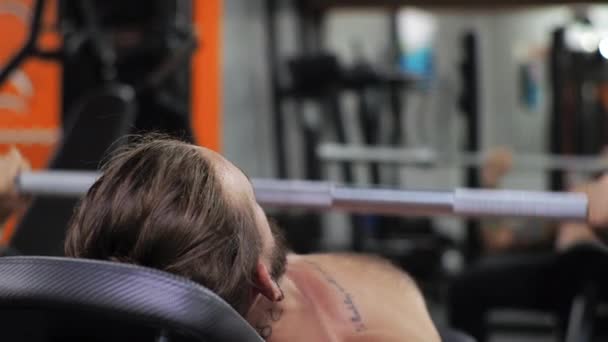 Jeune homme travaille dans la salle de gym Serieux concentré Secoue les bras, pousse l'haltère — Video