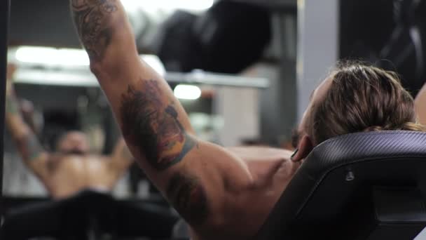 Jeune homme travaille dans la salle de gym Serieux concentré Secoue les bras, pousse l'haltère — Video