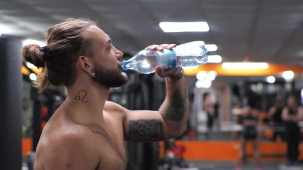 Joven trabaja en el gimnasio Serious focus Bebe agua — Vídeo de stock