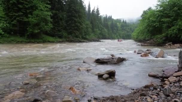 Ludzie radzą sobie w dół rzeki na dmuchanych tratwach Deszcz — Wideo stockowe