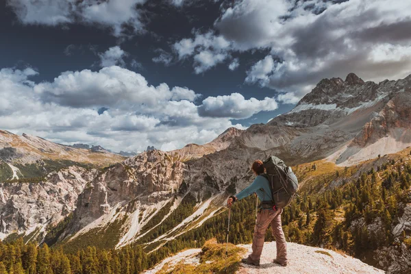 Sırt çantalı bir yürüyüşçü dağın tepesinde duruyor. — Stok fotoğraf