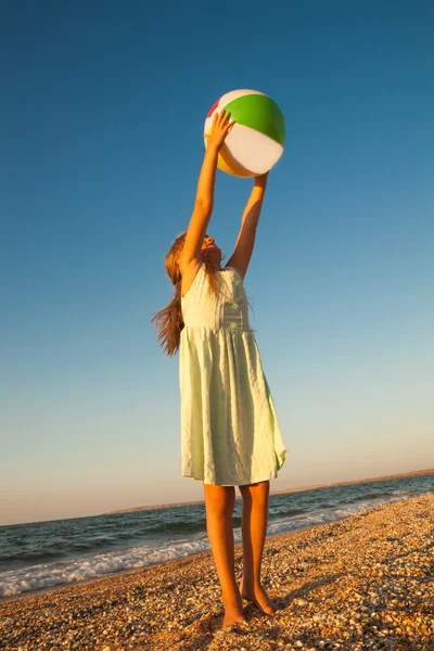 Adorable jeune fille jouant au ballon sur la plage de sable — Photo