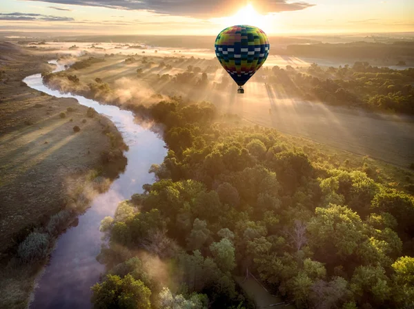 Varmluftsballong över floden vid solnedgången — Stockfoto