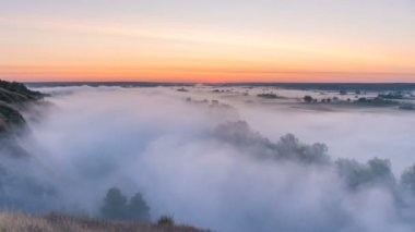 Nehir ve gündoğumu arka plan üzerinde çayır üzerinde curling Timelapse sis