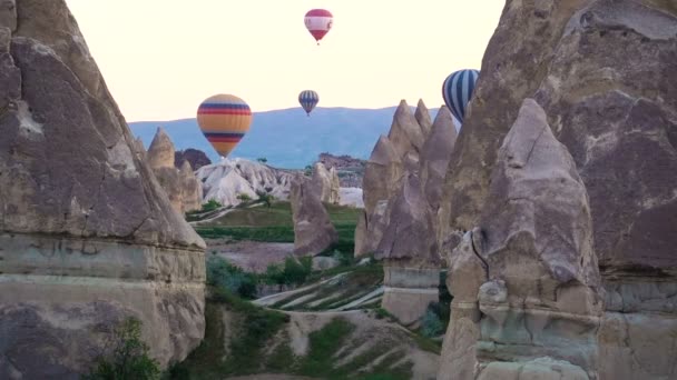 Muchos globos aerostáticos volando sobre valles en Goreme, Turquía. — Vídeos de Stock