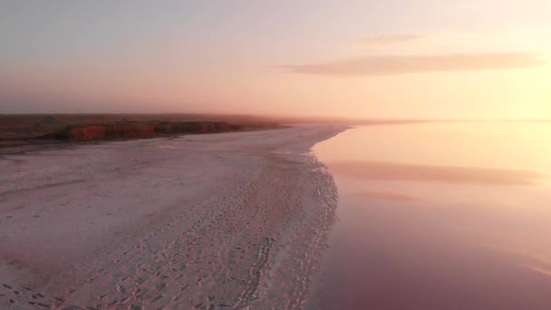 Flygdrönare vy till dimmiga Salt mineral sjö med rosa vatten och kust — Stockvideo