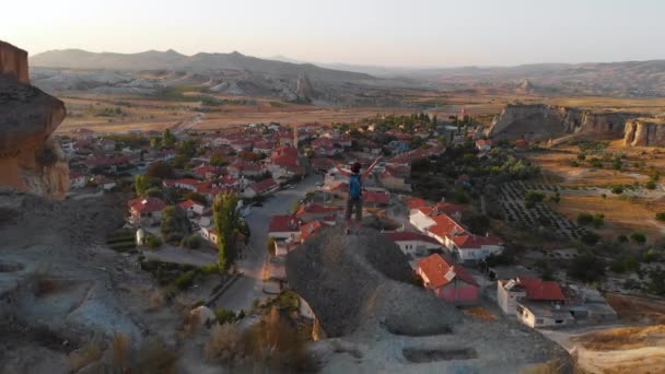 Vista aérea del dron de Cavusin Capadocia. Turista mujer y turco pueblo — Vídeos de Stock
